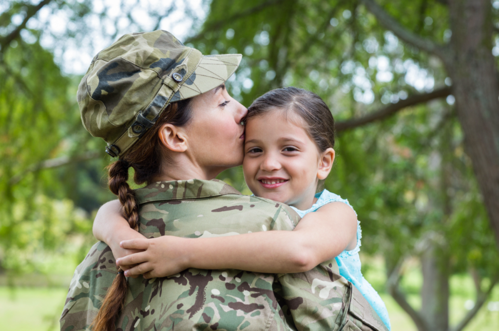 A female soldier embraces her smiling daughter